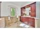 Updated bathroom features cherry cabinets, tile floor, and large window with a view of greenery at 51 Falcon Hills Dr, Highlands Ranch, CO 80126