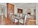 Open-concept dining room with hardwood floors, a glass table and view to fireplace at 51 Falcon Hills Dr, Highlands Ranch, CO 80126