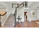 Elegant entryway with hardwood floors, staircase with black railings, and view into the kitchen at 51 Falcon Hills Dr, Highlands Ranch, CO 80126