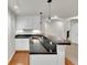 The basement kitchenette features white cabinets, a bar top, and wood floors at 51 Falcon Hills Dr, Highlands Ranch, CO 80126