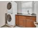Well-lit laundry room features stacked washer and dryer, cabinets and sink at 51 Falcon Hills Dr, Highlands Ranch, CO 80126