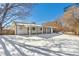 Snowy backyard view, showcasing a ranch-style home with covered patio at 4441 E Montana Pl, Denver, CO 80222