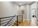 Hallway with modern railing and wood floors with view into the bedroom at 4125 Tejon St, Denver, CO 80211