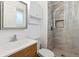 Modern bathroom featuring a sink, toilet, and a tiled shower with glass door at 5800 W Warren Ave, Denver, CO 80227