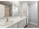 Bright bathroom featuring double sink vanity, tile countertops, and a large mirror in a clean, modern space at 5800 W Warren Ave, Denver, CO 80227