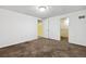 Bright bedroom with carpet, white walls, a ceiling light, and doors, providing a simple and functional living space at 5800 W Warren Ave, Denver, CO 80227