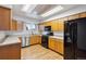 Charming kitchen with wooden cabinets, black appliances, and a bright, airy skylight at 5800 W Warren Ave, Denver, CO 80227