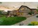 Sprawling backyard featuring mature trees, lush lawn, and a stone patio with a firepit at 2891 Waterfront Dr, Monument, CO 80132