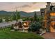Relaxing outdoor area with a stone fire pit, Adirondack chairs, and scenic mountain and lake views at 2891 Waterfront Dr, Monument, CO 80132