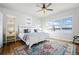 Bright bedroom featuring a ceiling fan, lake views, and a cozy rug on hardwood floors at 2891 Waterfront Dr, Monument, CO 80132