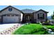 Charming single-story home with a stone archway entrance, well-manicured lawn, and a two car garage at 2891 Waterfront Dr, Monument, CO 80132