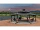 Community gazebo with picnic tables overlooking a lake, with mountain views on a partly cloudy evening at 2891 Waterfront Dr, Monument, CO 80132