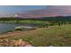 Scenic community lake featuring a walking path, dock and beautiful mountain views at 2891 Waterfront Dr, Monument, CO 80132