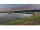 Community lake surrounded by grassy fields and wildflowers with scenic mountain views at 2891 Waterfront Dr, Monument, CO 80132