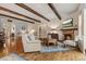 Elegant living room with hardwood floors, beamed ceilings, and a cozy stone fireplace at 2891 Waterfront Dr, Monument, CO 80132