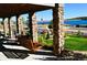 Covered porch with a wood swing, stone columns, and scenic waterfront views at 2891 Waterfront Dr, Monument, CO 80132