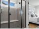 Modern shower featuring sleek tiling, a bench, and glass enclosure at 2891 Waterfront Dr, Monument, CO 80132