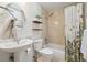 Charming bathroom featuring a pedestal sink, tiled shower-tub combo, decorative shelves, and neutral walls at 8780 Chase Dr # 40, Arvada, CO 80003