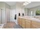 Bathroom featuring double sinks, wood cabinets, tile floors, and a separate shower area at 2550 Gold Creek Dr, Elizabeth, CO 80107