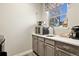Compact kitchenette features gray cabinets, sleek appliances, and a charming view from the window at 2550 Gold Creek Dr, Elizabeth, CO 80107