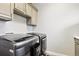Modern laundry room with upper cabinets and sleek, front-load washer and dryer units at 2550 Gold Creek Dr, Elizabeth, CO 80107
