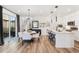 Modern kitchen with white cabinetry, stainless steel appliances, breakfast bar, dining area and bright lighting at 2907 Distant Rock Ave, Castle Rock, CO 80109