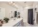 This bathroom has white tiling and a gray vanity with lots of lighting and a shower at 147 Silver Rock Trl, Castle Rock, CO 80104
