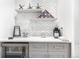 Convenient bar area featuring beverage cooler, upper cabinets, and eye catching backsplash at 10524 Eby Cir, Lone Tree, CO 80124