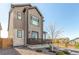 Side view of a modern home highlighting the stone accents, tidy landscaping, and a fenced yard at 10524 Eby Cir, Lone Tree, CO 80124