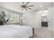 Sunlit main bedroom with large windows, neutral decor, and a glimpse of the en-suite bathroom at 10524 Eby Cir, Lone Tree, CO 80124