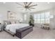 Bright main bedroom with large windows, gray accents, ceiling fan, and comfortable furnishings at 10524 Eby Cir, Lone Tree, CO 80124