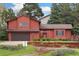 Charming two-story red home with lush landscaping and a two-car garage at 6293 Ponderosa Way, Parker, CO 80134