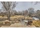 A backyard view with a creek, stone steps, mature trees and natural landscape at 6009 Yarrow St # B, Arvada, CO 80004