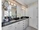 Bathroom with white cabinets, dual sinks, granite countertops and decorative mirror at 1011 N Pennsylvania St # H, Denver, CO 80203