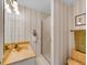 Bathroom featuring neutral striped wallpaper, a glass door shower, and a coordinated sink and toilet at 1011 N Pennsylvania St # H, Denver, CO 80203