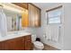 Bathroom featuring cherry cabinets, large mirror, and a window for natural light at 1853 S Zeno Way, Aurora, CO 80017