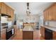 Bright kitchen and dining area with wood cabinets and stainless steel oven at 1853 S Zeno Way, Aurora, CO 80017