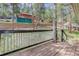 Wooden deck with white railings offering a glimpse of the surrounding landscape and a second home at 29762 Spruce Rd, Evergreen, CO 80439