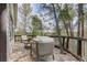 Outdoor seating area on a wooden deck, surrounded by trees at 29762 Spruce Rd, Evergreen, CO 80439