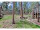 View of the landscaped backyard featuring a retaining wall, mature trees, and pathway at 29762 Spruce Rd, Evergreen, CO 80439