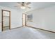 Clean, carpeted bedroom features a ceiling fan, closet, and a window for natural light at 29762 Spruce Rd, Evergreen, CO 80439