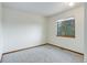 A bedroom featuring neutral walls and carpet with a window looking out to a wooded area at 29762 Spruce Rd, Evergreen, CO 80439