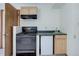 Compact kitchenette with an electric range, mini-fridge, wooden cabinets, and laminate countertops at 29762 Spruce Rd, Evergreen, CO 80439