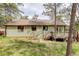 Back exterior view of house featuring a wooden deck and natural landscape with mature trees in the backyard at 29762 Spruce Rd, Evergreen, CO 80439