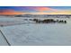Sweeping aerial of a snow-blanketed property featuring a fenced perimeter and distant mountain views at 4075 Merada Ct, Franktown, CO 80116