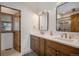 Beautiful bathroom featuring double sinks, white countertops, and a stylish, framed, glass-enclosed shower at 4075 Merada Ct, Franktown, CO 80116