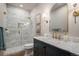 Modern bathroom with marble shower, vanity with marble countertop, and gold fixtures at 4075 Merada Ct, Franktown, CO 80116