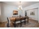 Formal dining area features a rustic wood table, modern chandelier, and contemporary wall decor at 4075 Merada Ct, Franktown, CO 80116