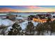 Beautifully landscaped home exterior at dusk featuring covered front porch, barn, playhouse and snow covered yard at 4075 Merada Ct, Franktown, CO 80116