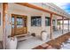 Inviting front porch with wooden beams, large door, and planters at 4075 Merada Ct, Franktown, CO 80116